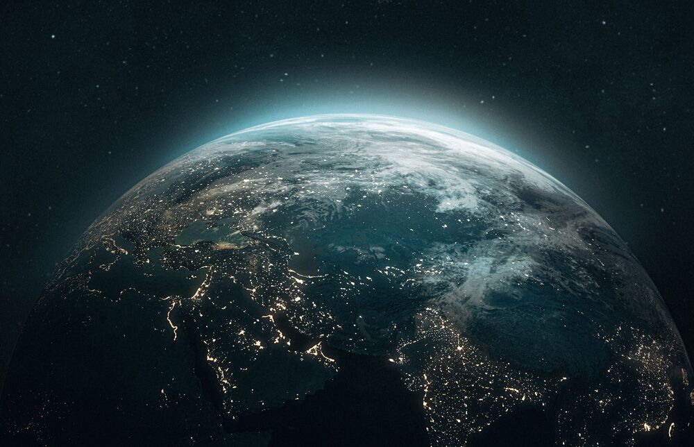 Office building windows showing lobby stairs and two associates sitting on a bench inside